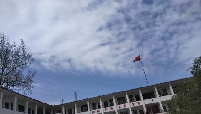 黔东南州凯旋工业学校国旗下的教学楼